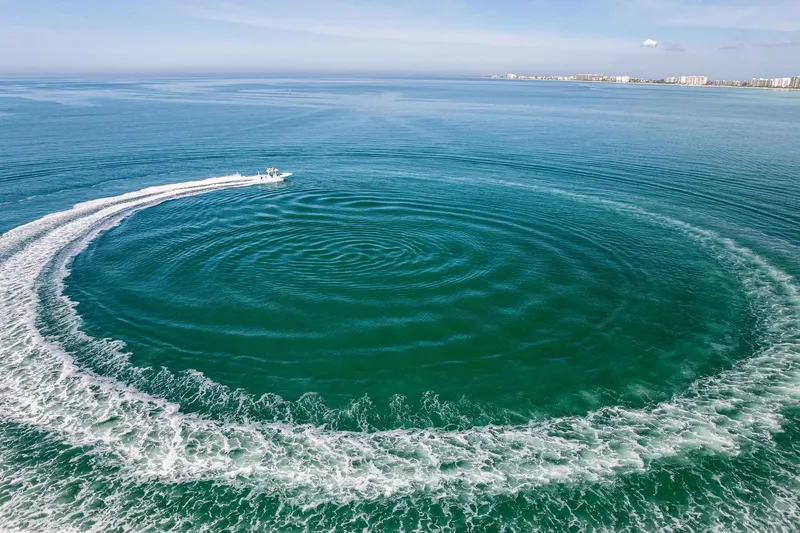 Slide: The Image of Aerial view of 2023 Barker Boatworks 26 Open creating circular wake pattern in ocean. - 49