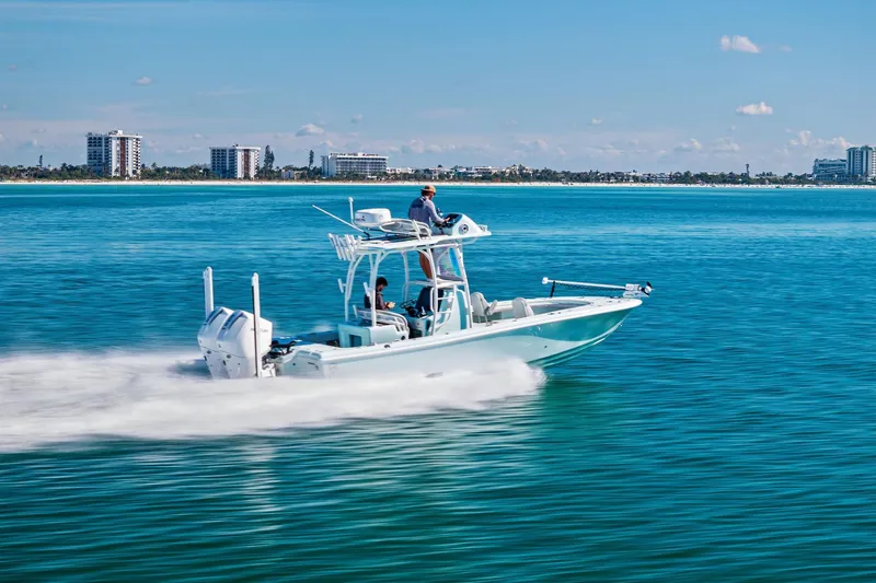 Slide: The Image of 2023 Barker Boatworks 26 Open cruising on clear blue water near a coastal city. - 53