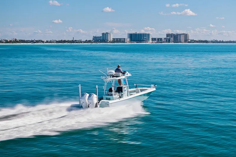 Slide: The Image of 2023 Barker Boatworks 26 Open cruising on clear blue ocean near city skyline. - 61