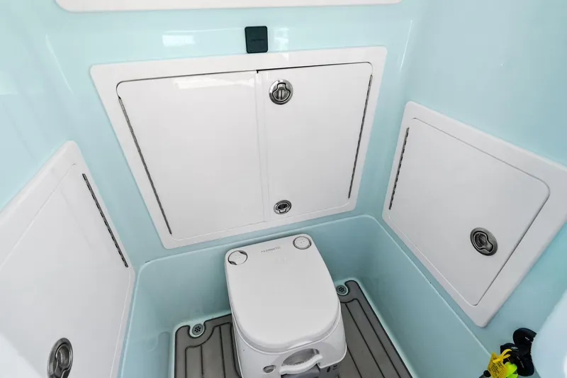 Slide: The Image of 2023 Barker Boatworks 26 Open interior with compact marine toilet and storage compartments. - 25