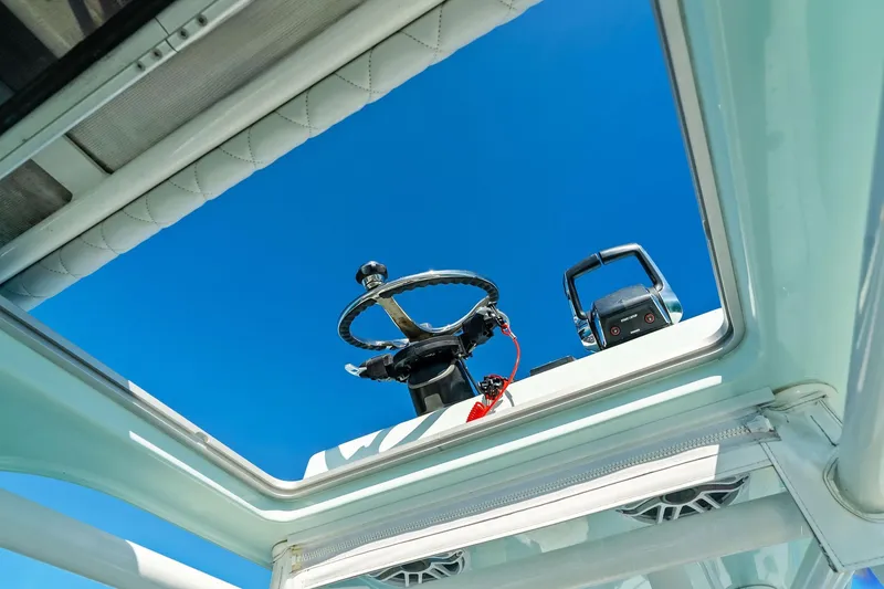 Slide: The Image of 2023 Barker Boatworks 26 Open steering wheel and controls under clear blue sky. - 26