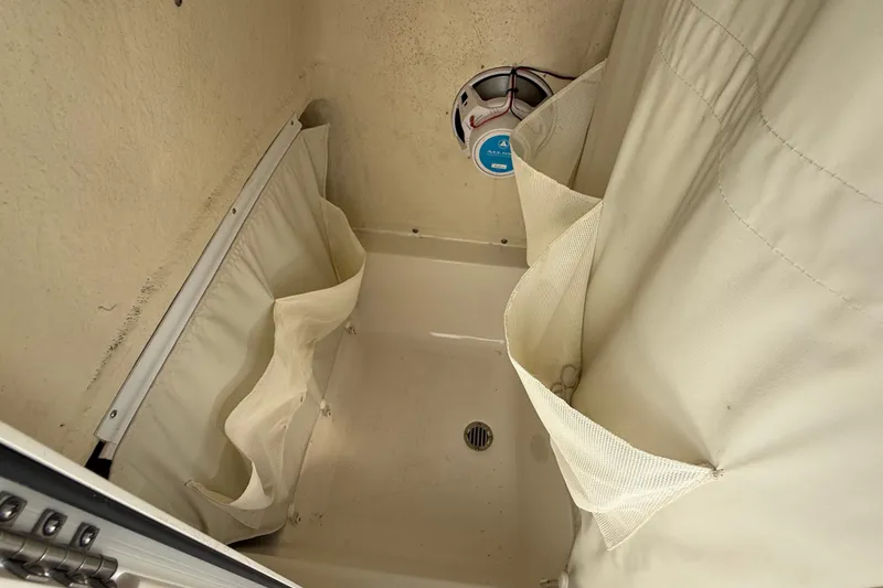 Slide: The Image of 2023 Key West 219 FS boat interior storage compartment with speaker and drain. - 39