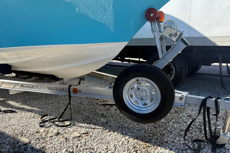 Slide: The Image of 2023 Key West 219 FS boat on Magic Tilt trailer, parked on gravel. - 45