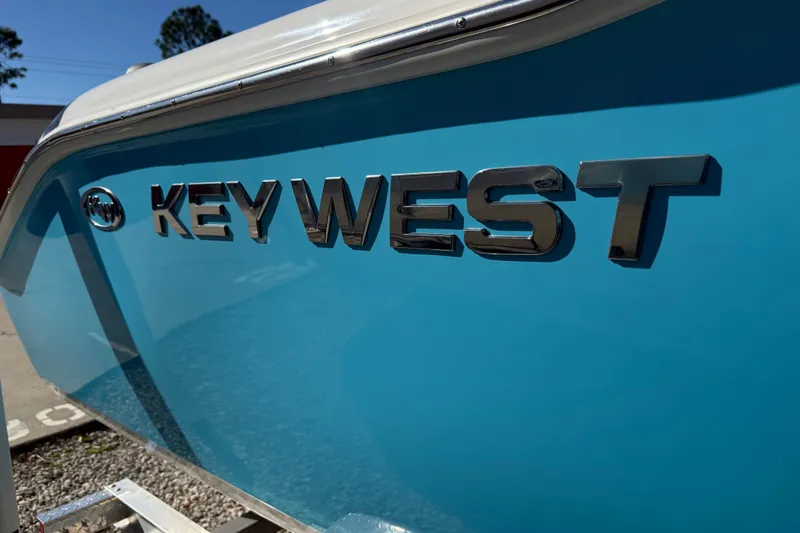 Slide: The Image of 2023 Key West 219 FS boat with shiny logo on blue hull. - 49