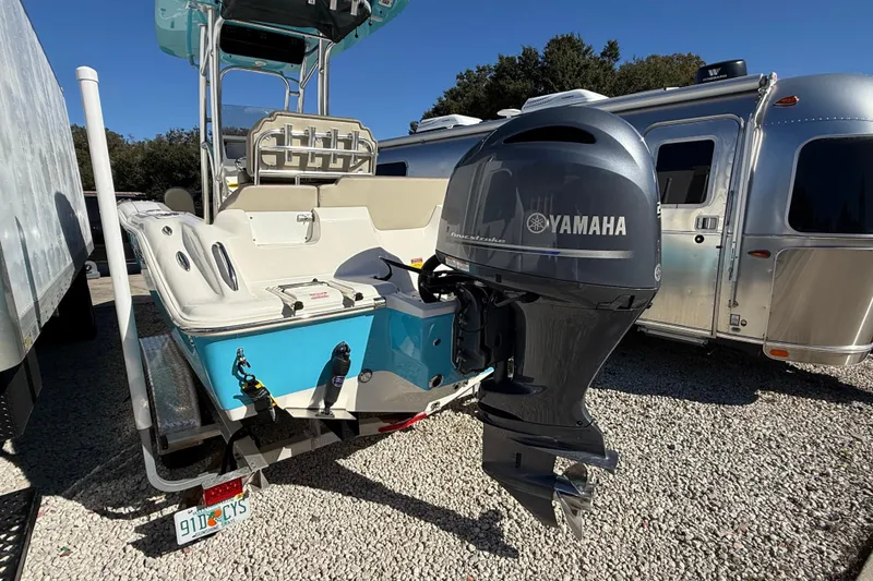 Slide: The Image of 2023 Key West 219 FS boat with Yamaha outboard motor, parked beside an Airstream trailer. - 53