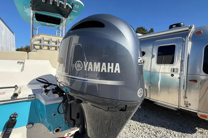 Slide: The Image of 2023 Key West 219 FS boat with Yamaha outboard motor, parked beside an Airstream trailer. - 54