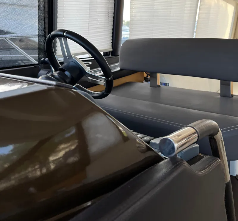 Slide: The Image of Interior of a 2013 Prestige 500 S yacht, featuring steering wheel and seating area. - 10