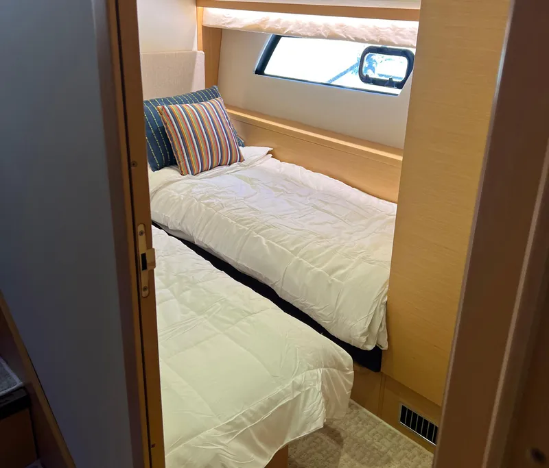 Slide: The Image of Cabin interior of 2013 Prestige 500 S yacht with twin beds and striped pillows. - 19