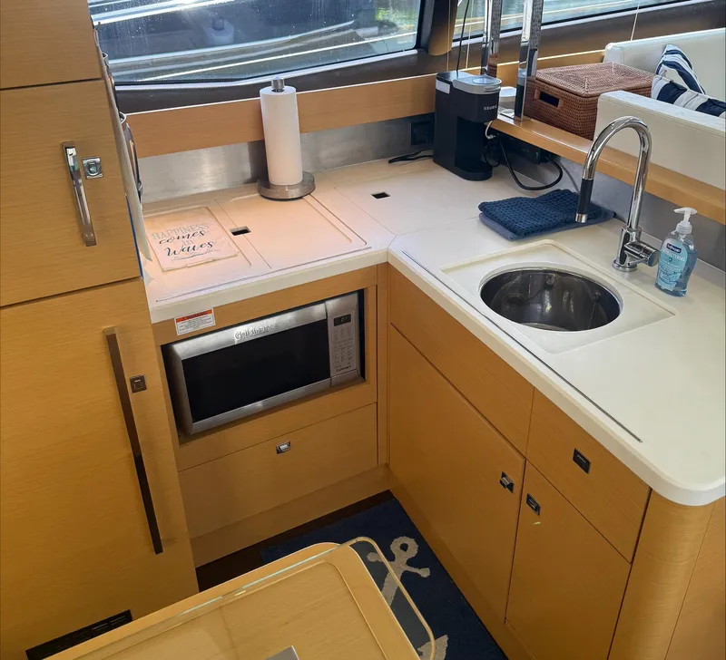 Slide: The Image of Modern kitchen in 2013 Prestige 500 S yacht with microwave, sink, and wooden cabinetry. - 2