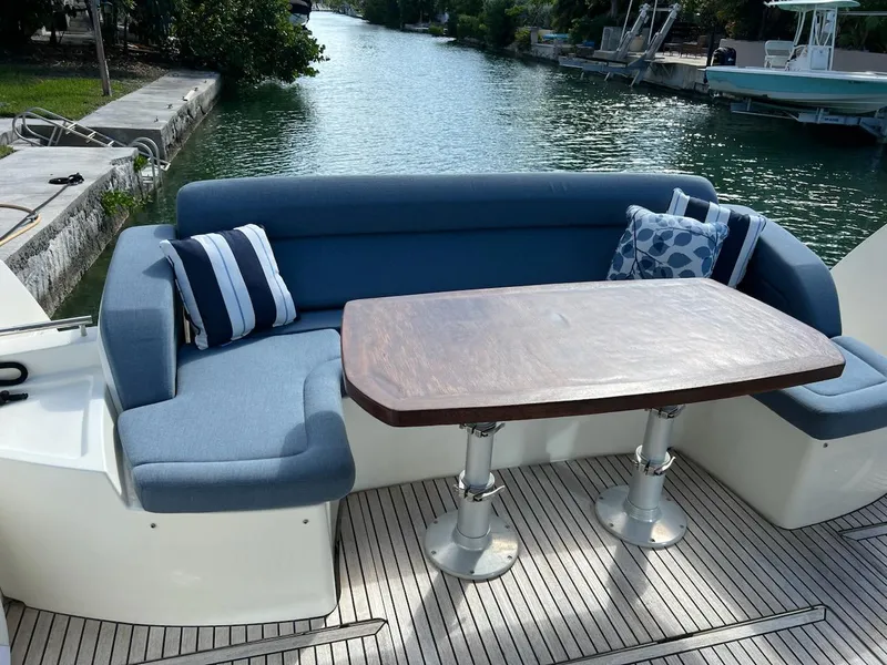 Slide: The Image of Outdoor seating area on a 2013 Prestige 500 S yacht with blue cushions and wooden table. - 30
