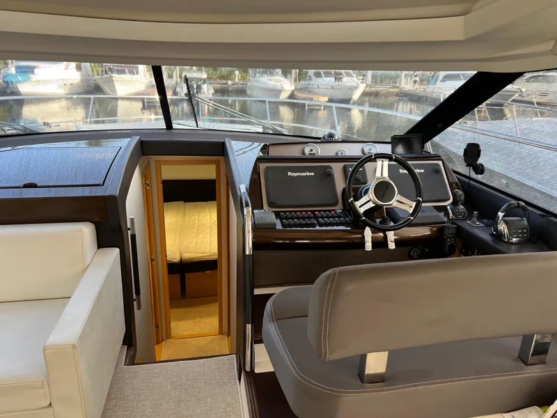 Slide: The Image of Interior of 2013 Prestige 500 S yacht, featuring helm, steering wheel, and cabin entrance. - 9