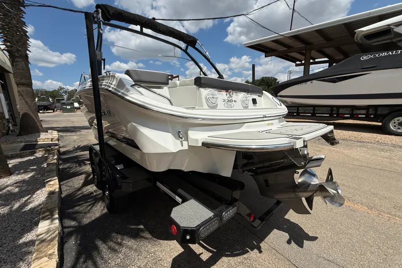 Slide: The Image of 2024 Cobalt 220S boat on trailer, rear view, sunny day, outdoor setting. - 4