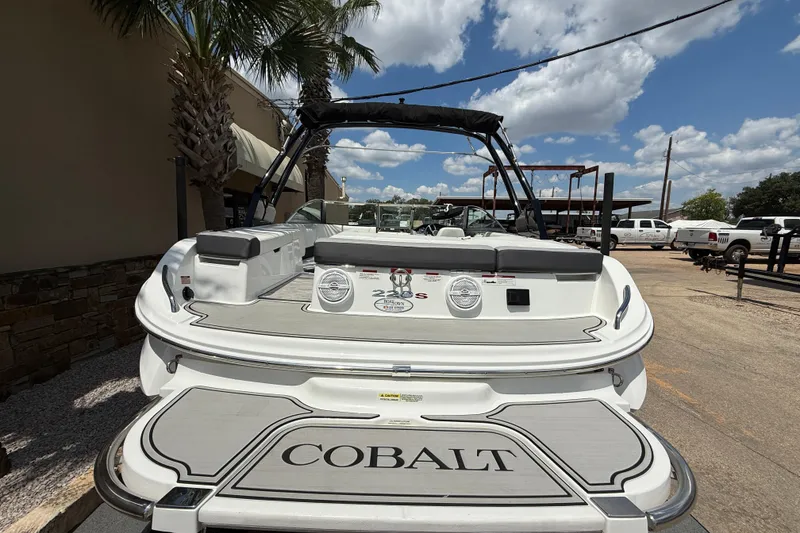 Slide: The Image of 2024 Cobalt 220S boat, rear view, parked outdoors under a sunny sky. - 6