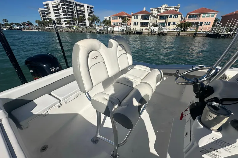Slide: The Image of 2018 Tidewater 232 LXF boat interior with helm, seating, and waterfront view. - 12