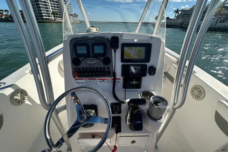 Slide: The Image of 2018 Tidewater 232 LXF boat console with steering wheel and navigation equipment on open water. - 15