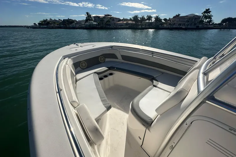 Slide: The Image of 2018 Tidewater 232 LXF boat interior with seating, on calm water, under clear sky. - 4