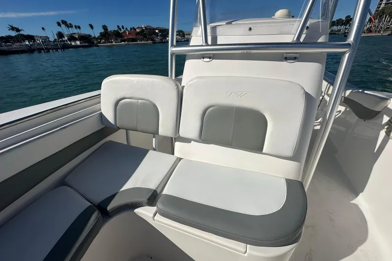 Slide: The Image of 2018 Tidewater 232 LXF boat seating with white and gray upholstery, ocean view in background. - 6