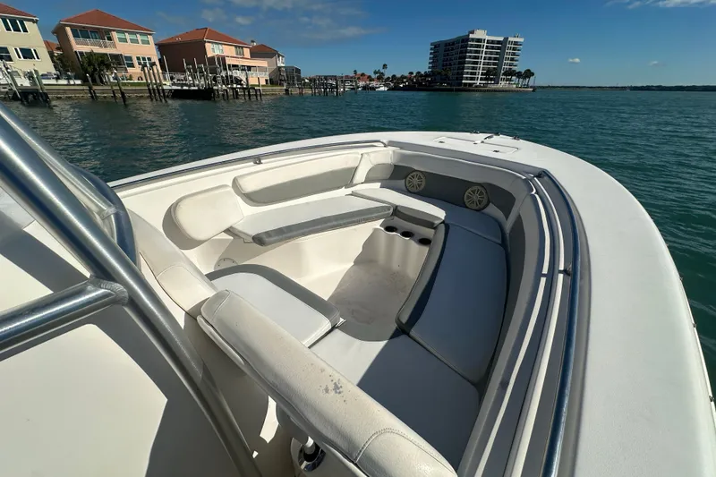 Slide: The Image of 2018 Tidewater 232 LXF boat interior with seating, dockside view, and waterfront buildings. - 7