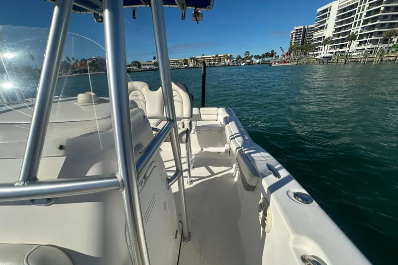 Slide: The Image of 2018 Tidewater 232 LXF boat on water, cityscape in background, sunny day. - 8