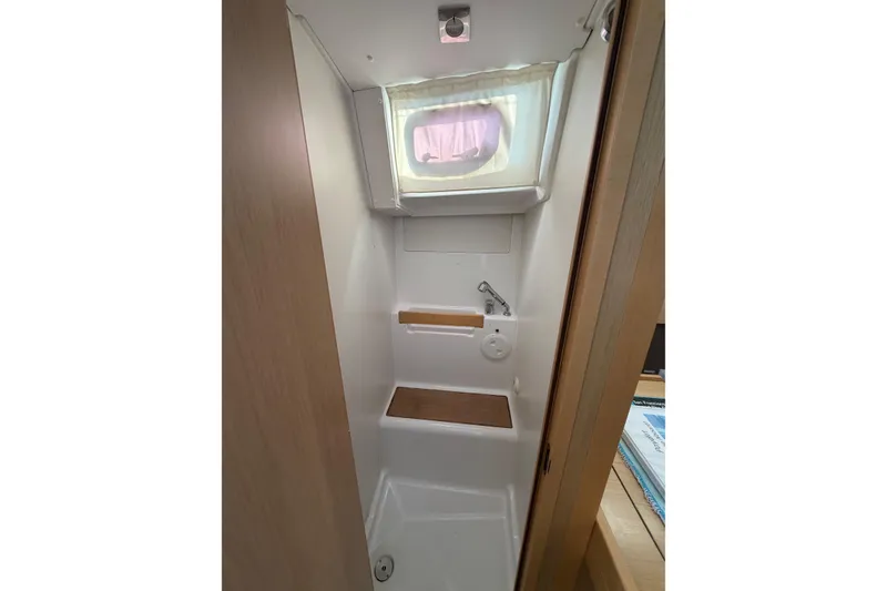 Slide: The Image of Bathroom interior of 2014 Beneteau 38 yacht with window and wooden accents. - 10