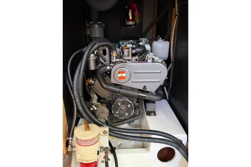 Slide: The Image of Engine compartment of a 2014 Beneteau 38 sailboat, showcasing mechanical components and hoses. - 11