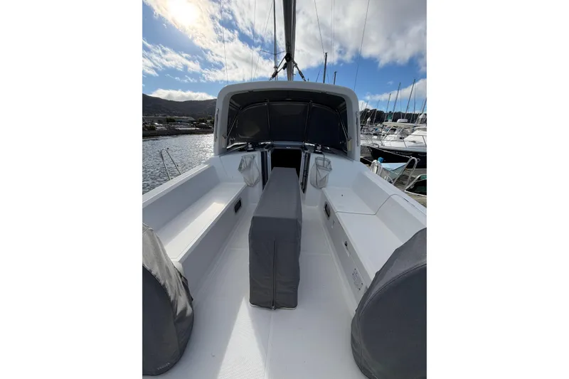 Slide: The Image of 2014 Beneteau 38 sailboat cockpit with seating, docked under a partly cloudy sky. - 12
