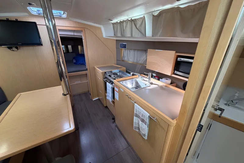 Slide: The Image of Interior of 2014 Beneteau 38 sailboat with kitchen, dining area, and sleeping quarters. - 7