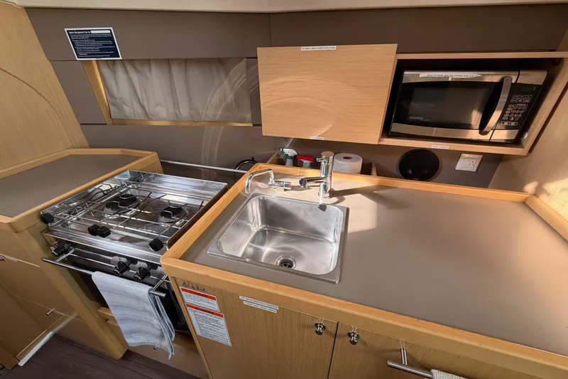 Slide: The Image of Compact kitchen in a 2014 Beneteau 38 yacht with stove, sink, and microwave. - 9