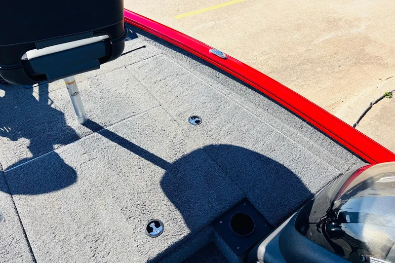 Slide: The Image of 2024 Tracker Pro Team 175 TXW boat interior with gray carpet and red trim. - 15