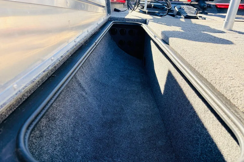 Slide: The Image of 2024 Tracker Pro Team 175 TXW boat interior storage compartment, carpeted and spacious. - 17