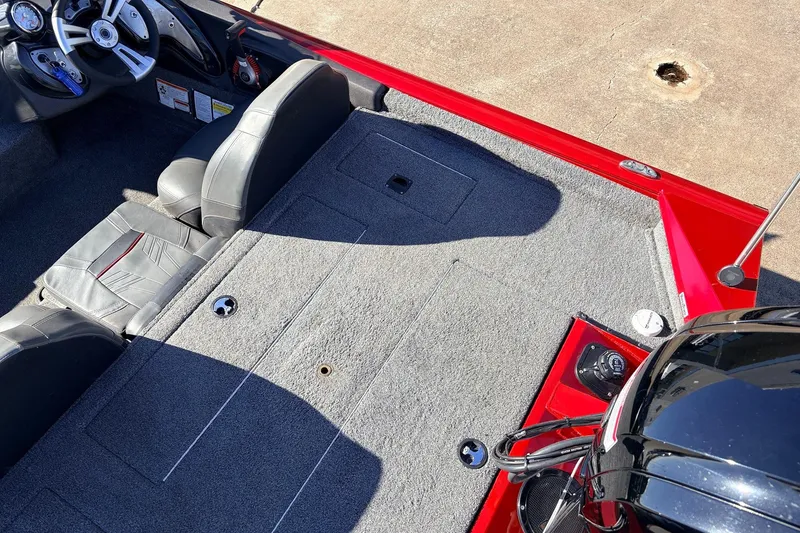 Slide: The Image of 2024 Tracker Pro Team 175 TXW boat interior with gray carpet and red accents. - 35