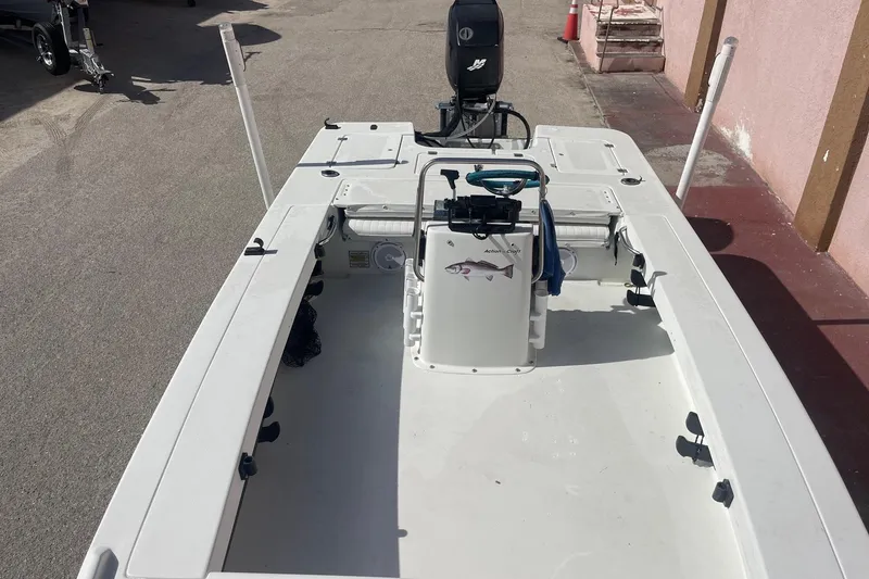 Slide: The Image of 2002 Action Craft 1802 boat with center console and outboard motor, parked on pavement. - 12