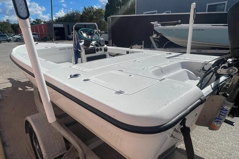 Slide: The Image of 2002 Action Craft 1802 boat on trailer, parked outdoors under sunny sky. - 3