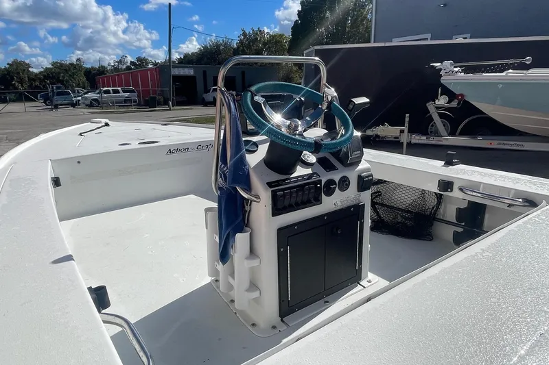 Slide: The Image of 2002 Action Craft 1802 boat interior with steering console, parked outdoors under blue sky. - 4