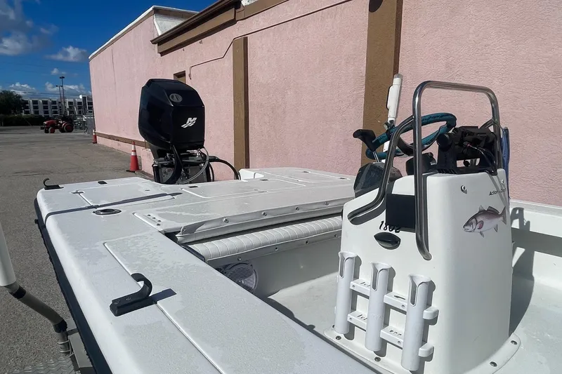 Slide: The Image of 2002 Action Craft 1802 boat with outboard motor, parked near a pink building. - 7