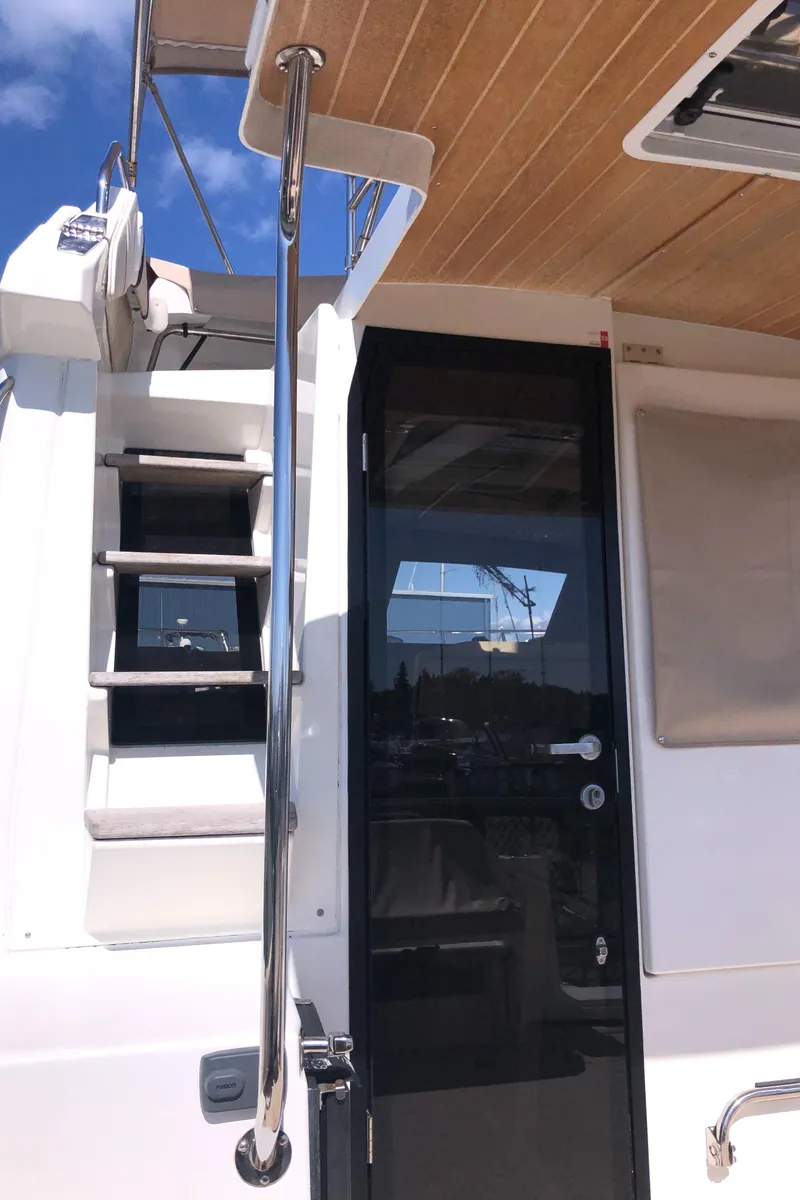 Slide: The Image of 2016 Cutwater 30 Command Bridge yacht with stairs and glass door, featuring sleek design elements. - 12