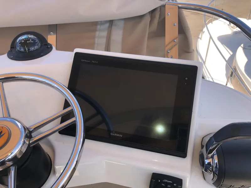 Slide: The Image of Steering wheel and Garmin display on 2016 Cutwater 30 Command Bridge boat. - 17