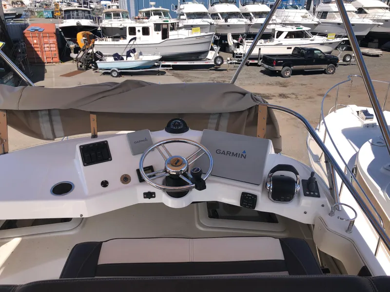 Slide: The Image of Helm of 2016 Cutwater 30 Command Bridge with Garmin navigation, docked among other boats. - 20