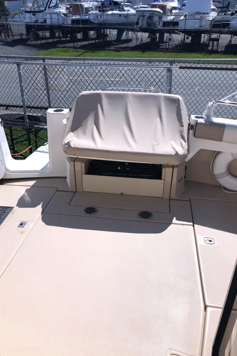 Slide: The Image of 2016 Cutwater 30 Command Bridge boat deck with covered seating, docked near marina. - 25