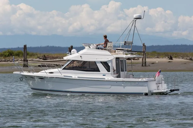 Slide: The Image of 2016 Cutwater 30 Command Bridge boat cruising on calm water with scenic background. - 3
