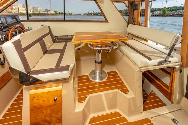 Slide: The Image of Interior of 2016 Cutwater 30 Command Bridge with seating and wooden table. - 34