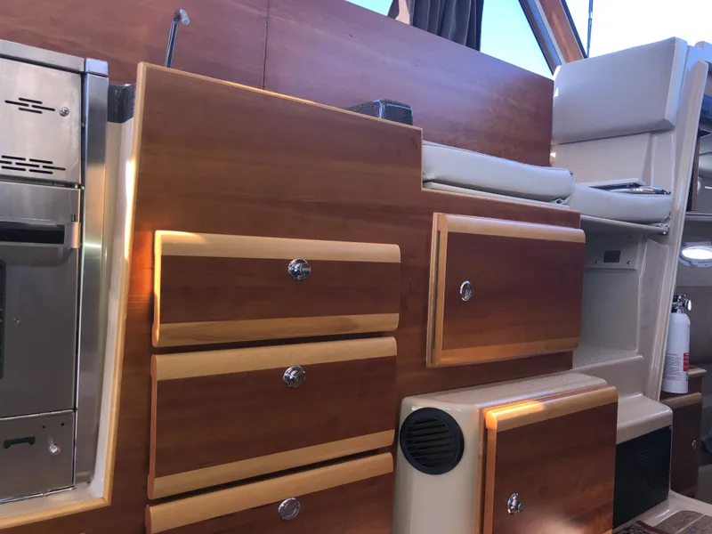 Slide: The Image of Interior of a 2016 Cutwater 30 Command Bridge with wooden cabinetry and seating. - 35