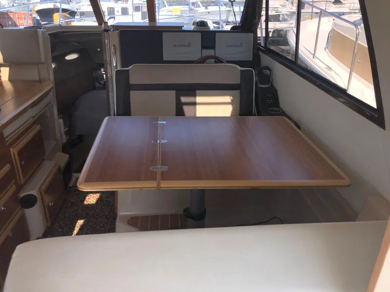 Slide: The Image of Interior of 2016 Cutwater 30 Command Bridge with wooden table and seating. - 45