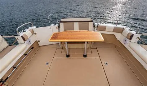Slide: The Image of 2016 Cutwater 30 Command Bridge boat deck with seating and wooden table. - 6
