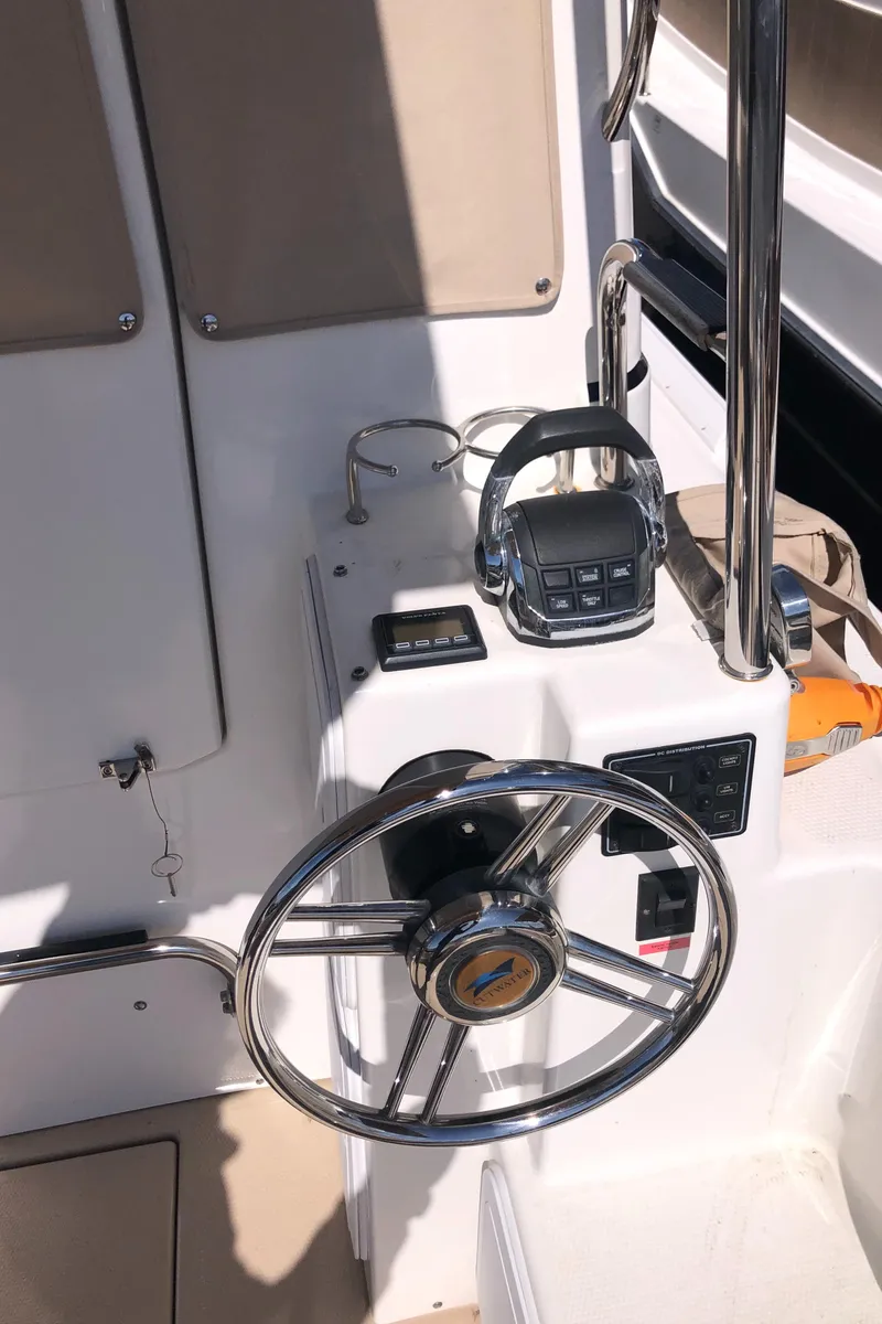 Slide: The Image of Steering wheel and controls of a 2016 Cutwater 30 Command Bridge boat. - 9