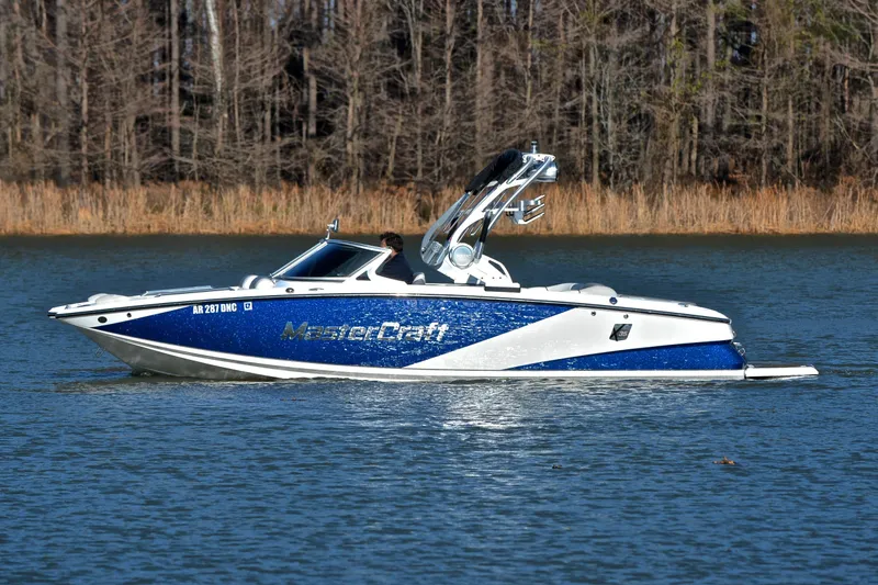 Slide: The Image of 2013 MasterCraft X-35 boat on a lake with wooded shoreline background. - 10