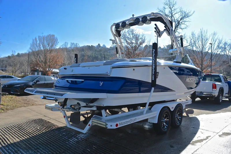 Slide: The Image of 2013 MasterCraft X-35 boat on trailer, blue and white, parked outdoors. - 15