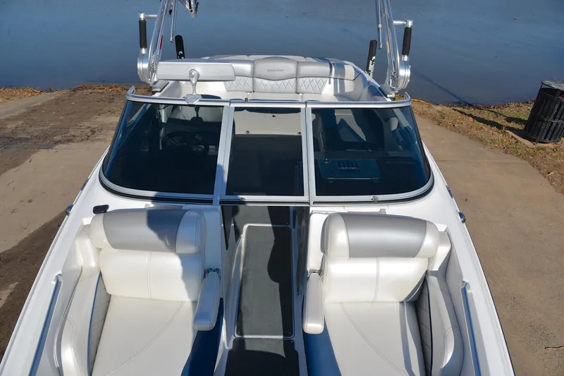 Slide: The Image of 2013 MasterCraft X-35 boat interior with white seating and windshield, docked by the water. - 21