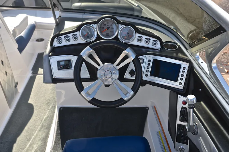 Slide: The Image of 2013 MasterCraft X-35 boat dashboard with steering wheel, gauges, and control panel. - 26