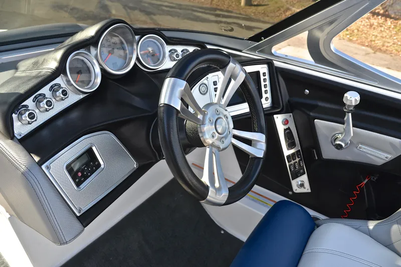 Slide: The Image of 2013 MasterCraft X-35 boat dashboard with steering wheel and control panel. - 27
